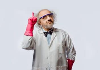 Scientifique avec un noeud papillon, des gants roses et des lunettes bleues, qui lève le doigt avec un regard comique